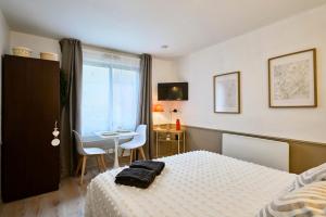 een slaapkamer met een bed, een tafel en een raam bij Studio Vauban, Lille in Lille
