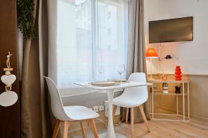 een witte tafel en stoelen in een kamer met een raam bij Studio Vauban, Lille in Lille +21 foto's