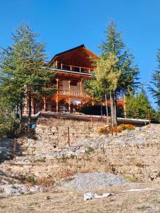 a large house on top of a stone wall at Himalayan Baseraa in Sainj +15 photos