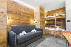 een woonkamer met een bank en een stapelbed bij Hostdomus-Mountain Nest in Sauze d'Oulx