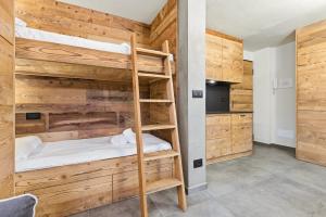 een stapelbed in een kamer met houten wanden bij Hostdomus-Mountain Nest in Sauze d'Oulx