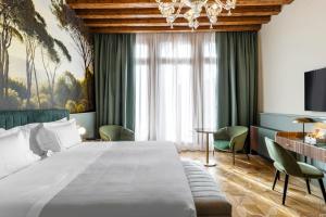 ein Hotelzimmer mit einem großen Bett und einem Tisch in der Unterkunft Hotel Villa Viridia in Venedig
