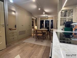 eine Küche mit Tisch und Esszimmer in der Unterkunft TatryTop Apartament Szałwiowy in Nowy Targ