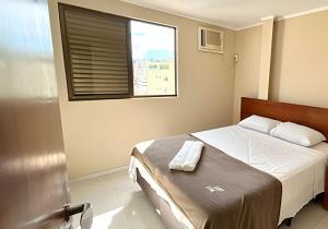 una piccola camera da letto con un letto e una finestra di Classe A a Viçosa Altre 93 foto