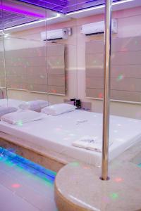 Bett in einem Zimmer mit Beleuchtung in der Unterkunft Pousada Olimpo in Ananindeua