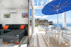 a living room with a couch and a table with an umbrella at Bahia Blanca in Puerto Rico de Gran Canaria