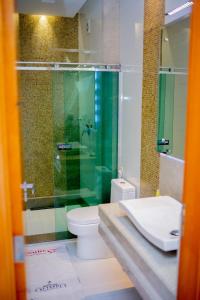 a bathroom with a glass shower and a toilet at Pousada Olimpo in Ananindeua +5 photos