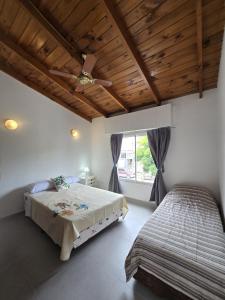 ein Schlafzimmer mit zwei Betten und einem Deckenventilator in der Unterkunft Apart Altos de Monte Hermoso in Monte Hermoso