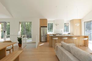 een woonkamer en keuken met een bank en een tafel bij Maison Solus - Mont Tremblant in Lac-Superieur