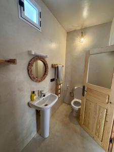 a bathroom with a sink and a toilet and a mirror at Atlantic refuge in Wassane