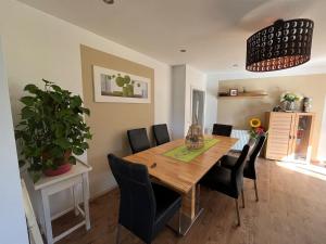 a dining room with a wooden table and black chairs at Ferienwohnung am Faaker See in Latschach