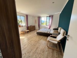 a bedroom with a bed and a chair in it at Ferienwohnung am Faaker See in Latschach