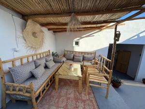 a patio with a couch and a table and chairs at Atlantic refuge in Wassane +62 photos