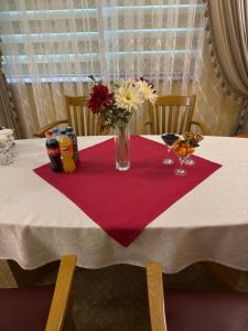 a table with a vase of flowers on a red napkin at Khorezm Palace Hotel in Urganch +20 photos