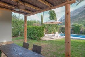 a patio with a table and an umbrella and a pool at Casa MaJa in Denia