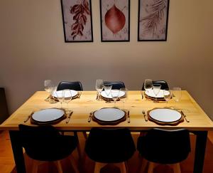 a wooden table with chairs and wine glasses at Apartamento Major Nicoletti in Gramado +23 photos