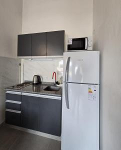 eine Küche mit einem weißen Kühlschrank und einer Spüle in der Unterkunft Apart Altos de Monte Hermoso in Monte Hermoso