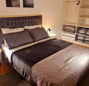 a bedroom with a large bed and a shelf at Apartamento Major Nicoletti in Gramado