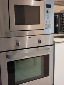 a microwave on top of an oven in a kitchen at Beach Hub in São Martinho do Porto +2 photos