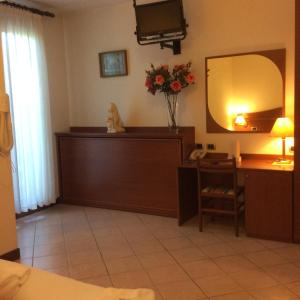 a room with a vanity and a mirror and a desk at Hotel Pizzeria Ristorante "Al Leone" in Villa del Conte