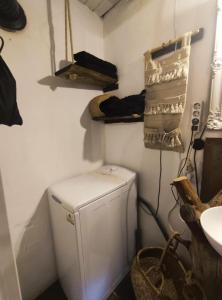 a small white refrigerator in a corner of a room at Menyecske Guesthouse in Keszü