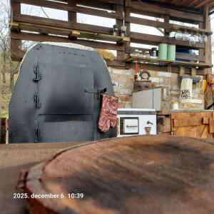 a outdoor kitchen with a grill and a stove at Menyecske Guesthouse in Keszü