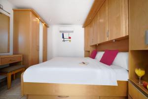 a bedroom with a large white bed with red pillows at Bahia Blanca in Puerto Rico de Gran Canaria