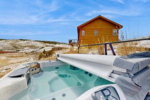 una vasca idromassaggio davanti a una casa rossa di Silver Sage Sanctuary a Granby