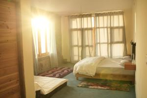 um quarto com duas camas e uma janela em Hobo Hostel em Dharamshala