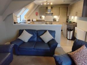 uma sala de estar com um sofá azul e uma cozinha em Turfhill House em New Deer mais 7 fotografias