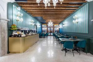 ein Restaurant mit blauen Wänden, Tischen und Stühlen in der Unterkunft Hotel Villa Viridia in Venedig