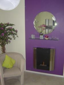 a living room with a fireplace and a chair and a mirror at Vollumen Business-Juniorsuite in Redwitz an der Rodach