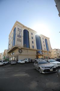 een groot gebouw met auto's geparkeerd op een parkeerplaats bij Lamar Al Bawadi Hotel in Jeddah