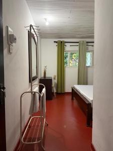 a room with a bed and a chair in it at Schanigarten in Deniyaya +5 photos