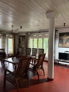 a dining room with a table and chairs and a television at Schanigarten in Deniyaya
