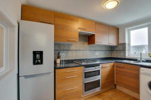a kitchen with wooden cabinets and a white refrigerator at 2 Bed in Mumbles oc-hh1201 in The Mumbles