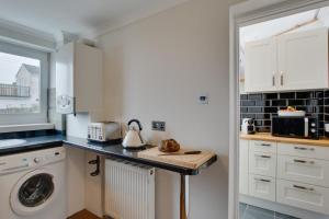 a kitchen with a washer and dryer on a counter at 2 Bed in Mumbles oc-hh1201 in The Mumbles +9 photos
