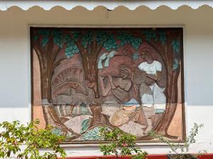 a mural on the side of a building at Schanigarten in Deniyaya