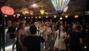 河江Lotus Hostel Ha Giang Loop的一群人在灯光的房间跳舞