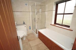een badkamer met een bad, een toilet en een wastafel bij 4 Bed in Gower oc-hh151 in Llangennith +58 foto's