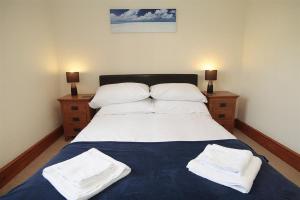 een slaapkamer met een bed met twee witte handdoeken erop bij 4 Bed in Gower oc-hh151 in Llangennith