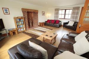 een woonkamer met een leren bank en een salontafel bij 4 Bed in Gower oc-hh151 in Llangennith