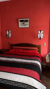 een slaapkamer met een bed met een rode muur bij Casa María Victoria 