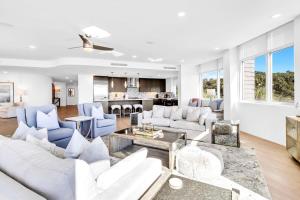 a living room with white furniture and a kitchen at Viridian 201 in Santa Rosa Beach