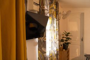 a television on top of a refrigerator in a room at Bel La Vi Apartment in Le Lamentin