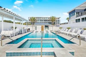 a swimming pool with chairs and a building at Viridian 201 in Santa Rosa Beach