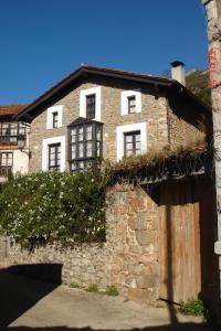 una vecchia casa in pietra con l'edera che cresce sopra di Casa Colonial en Alevia ad Alevia