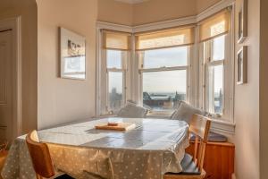 a dining room with a table and a window at The Crow's Nest - Elie in Elie +11 photos
