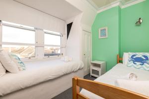 a bedroom with two beds and a window at The Crow's Nest - Elie in Elie