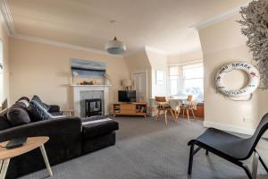 a living room with a couch and a table at The Crow's Nest - Elie in Elie